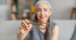 Purchased - elderly gray-haired female holding glasses in living room