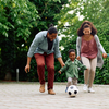 Purchaed - Happy parents and their kids playing with soccer ball in the park