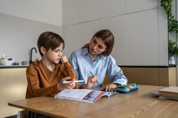 Purchased - boy feeling frustrated while doing homework with mom at home