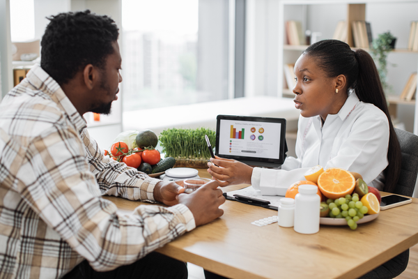 Purchased - Expert in diet displaying client's data on tablet via graphs