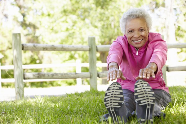 Purchased - Senior woman stretching in the park