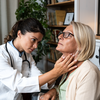 Limited - Doctor checking a woman's thyroid