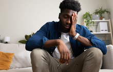 Purchased -  man sitting on the couch not feeling well