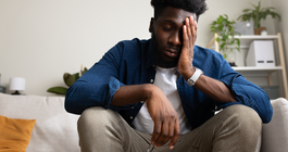 Purchased -  man sitting on the couch not feeling well
