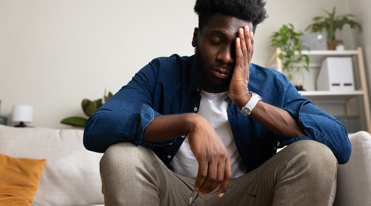 Purchased -  man sitting on the couch not feeling well