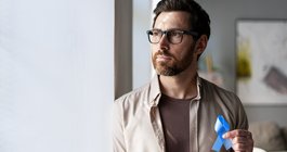 Purchased - Man holding blue ribbon supporting colon cancer awareness