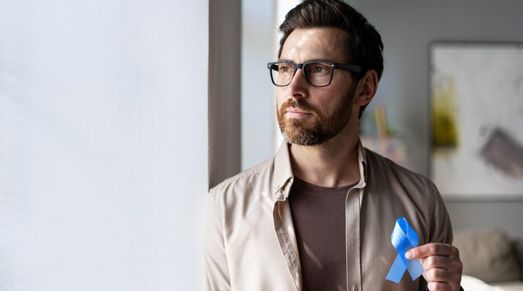 Purchased - Man holding blue ribbon supporting colon cancer awareness