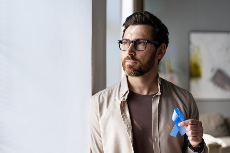 Purchased - Man holding blue ribbon supporting colon cancer awareness