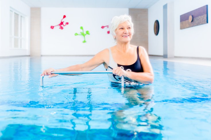 Purchased - senior citizen in a pool exercising