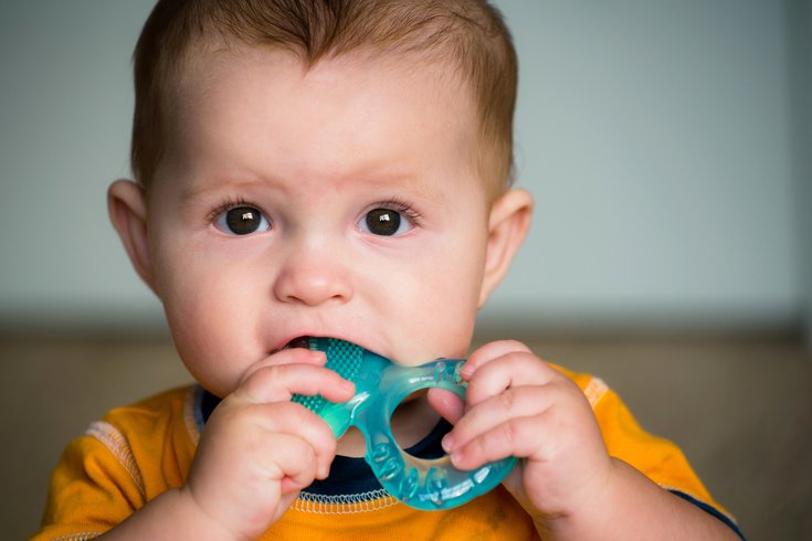 Baby chewing on teething ring stock photo