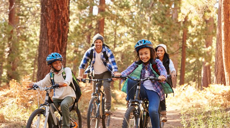 Family riding bikes in the woods