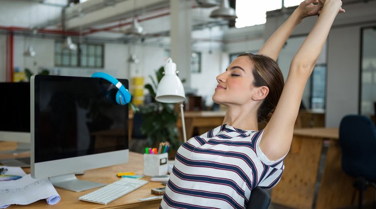 Woman stretching at her work desk