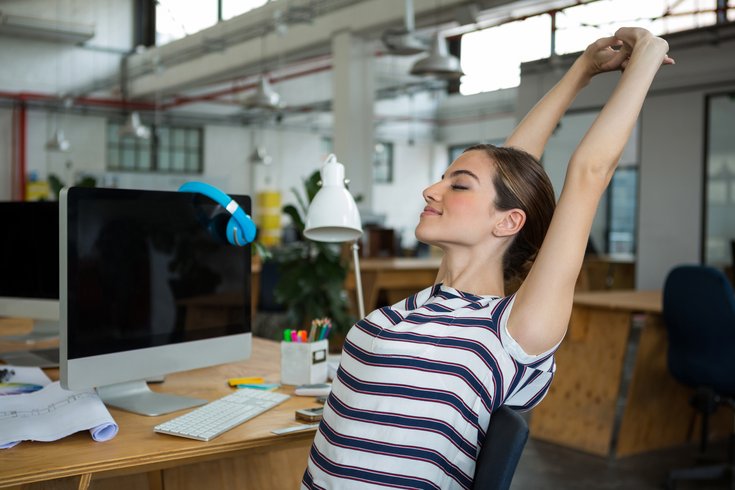 Woman stretching at her work desk