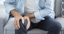 Purchased - Older person holding their knee in pain