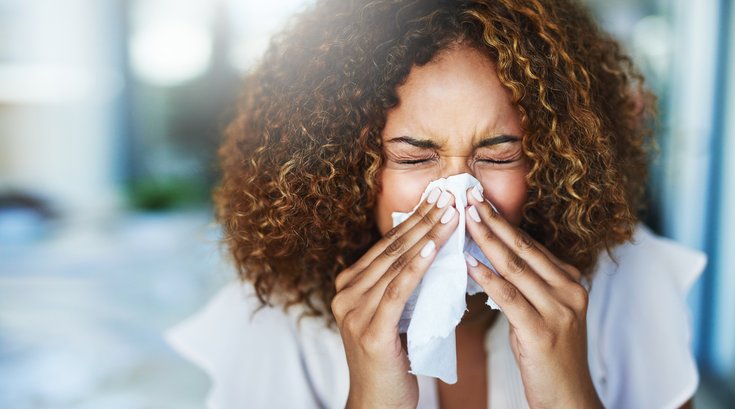Woman blowing her nose