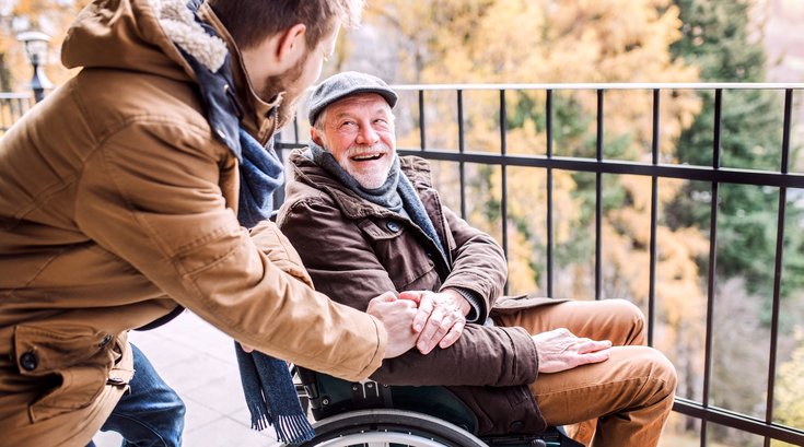 Senior father in wheelchair and young son