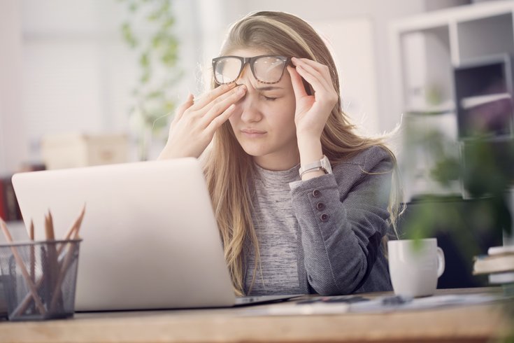 Woman with a headache at work