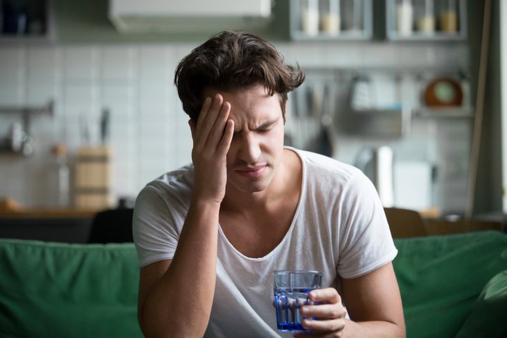 Man sitting on couch feeling groggy