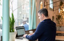 A salesperson checking a laptop in a coffee shop
