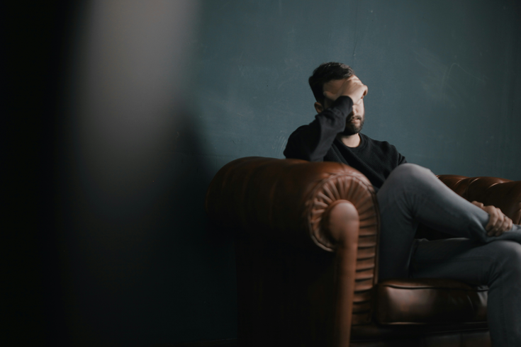 Stressed out person sitting on a couch upset