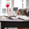 Tired woman with head on desk during day