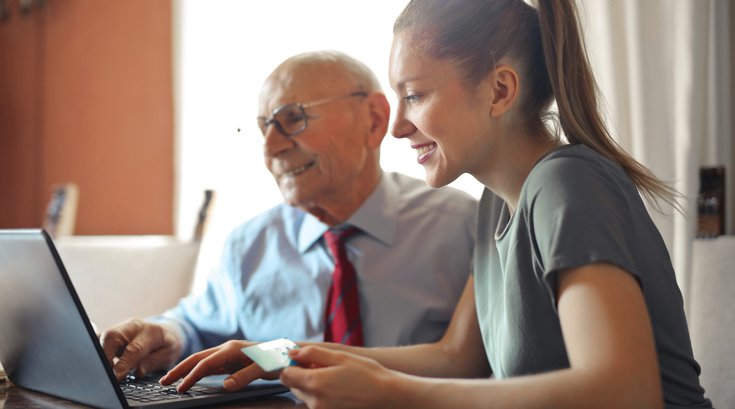 Young woman helping elderly man with finances