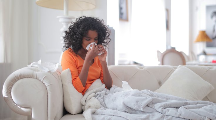 Woman suffering from allergies on her couch