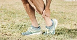 A man holding his leg in pain