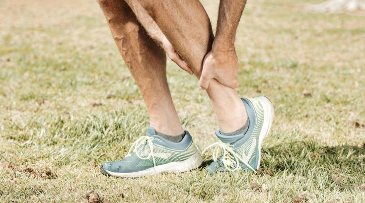 A man holding his leg in pain