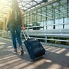 Woman walking on pathway while strolling luggage