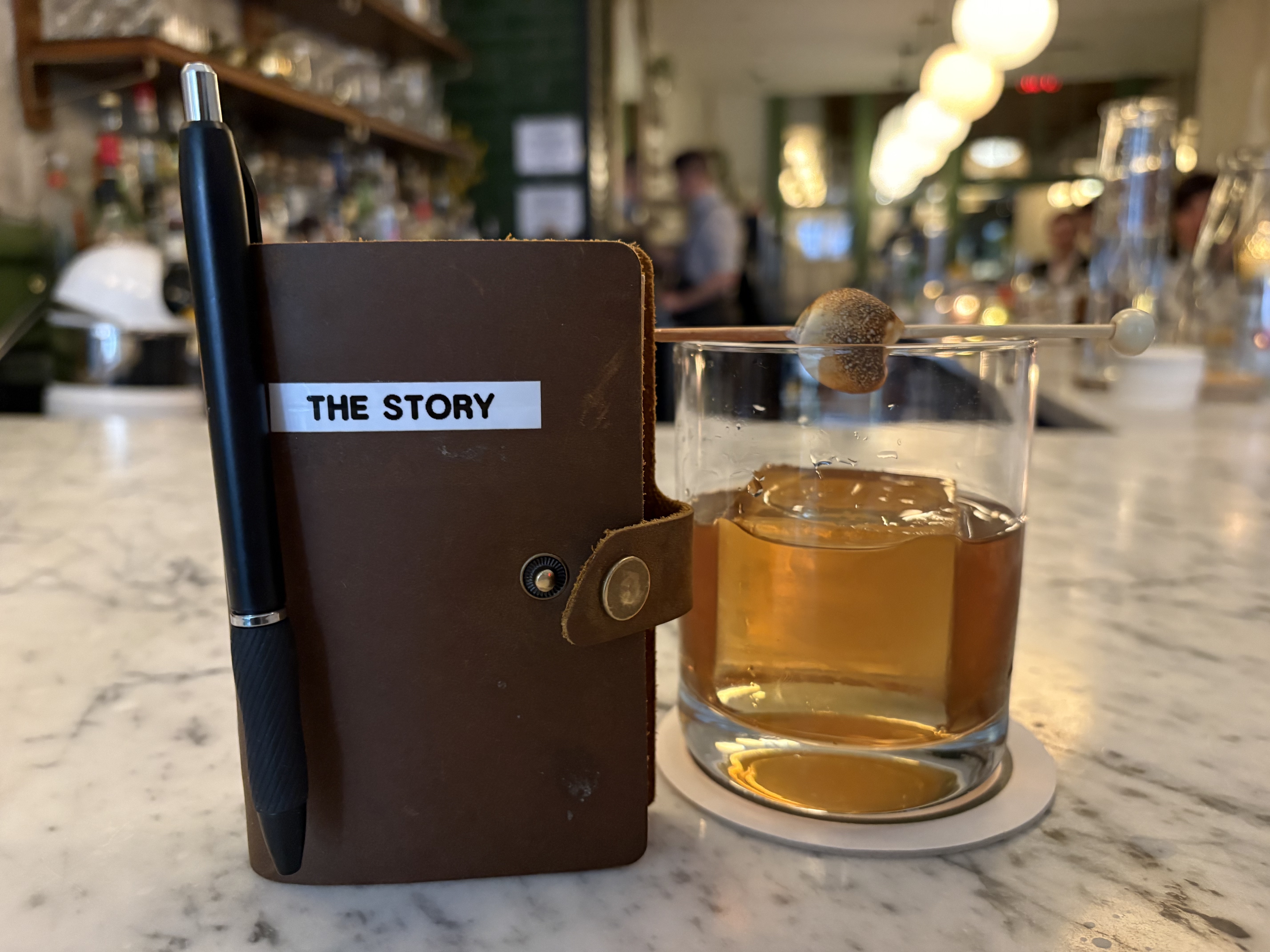 This Forsythia bourbon cocktail comes with a novel garnish — an ongoing, crowd-sourced story